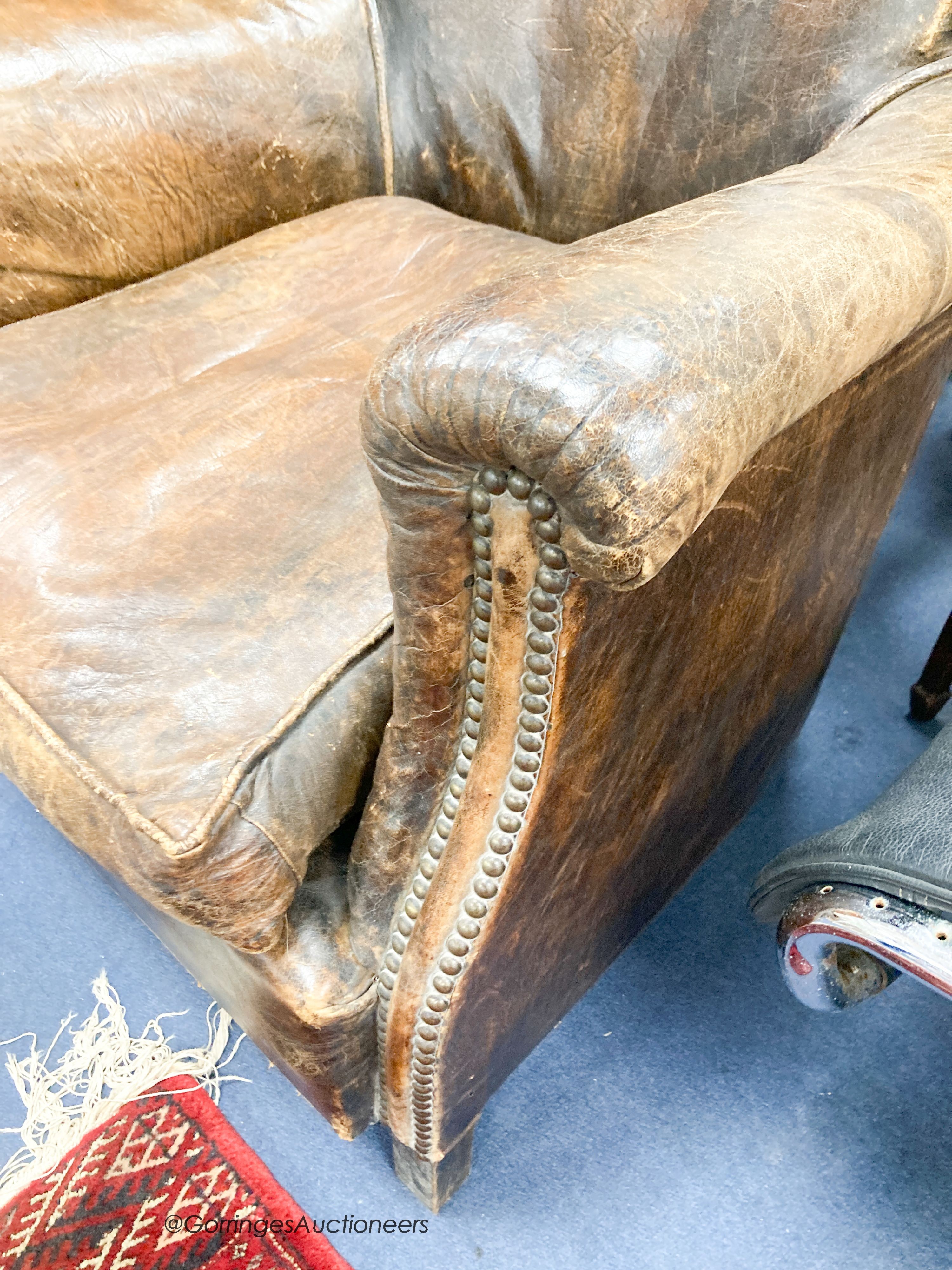 An early 20th century brown leather club armchair, width 78cm, depth 70cm, height 71cm